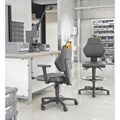 Industrial swivel chair, black, with sit-stop castors and foot ring, vinyl cover.